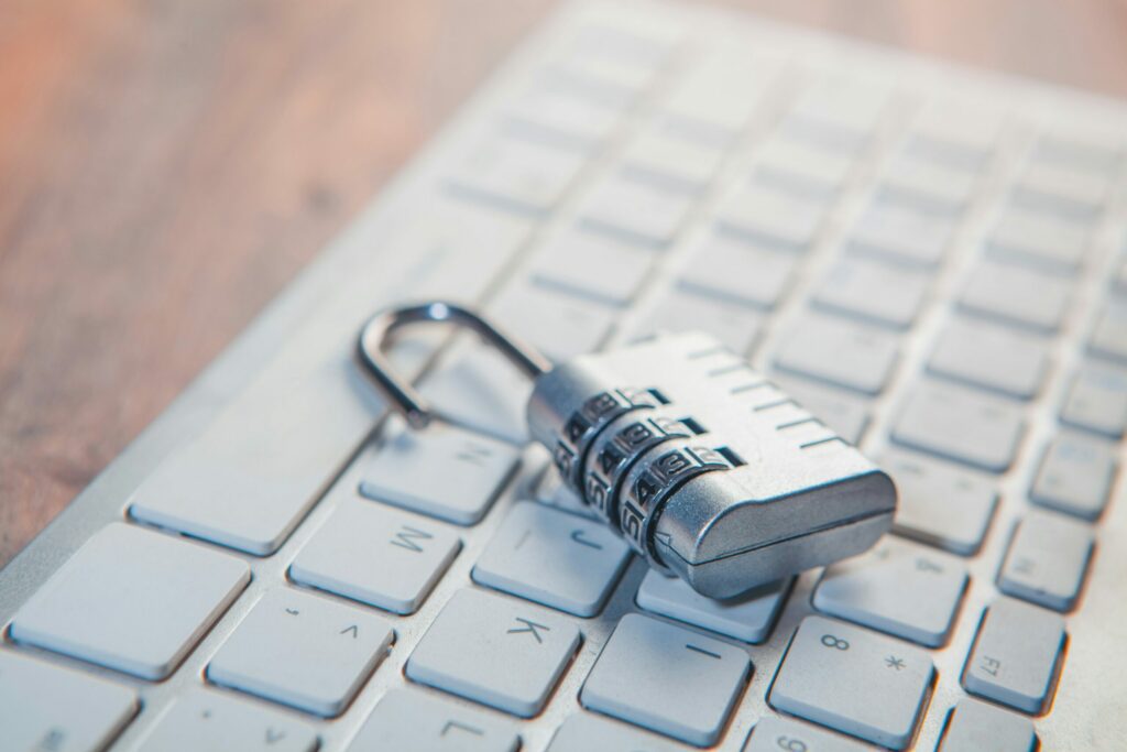 A combination lock rests on a computer keyboard.